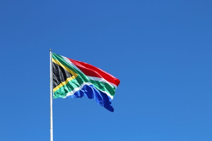 South African flag waving over the blue sky.