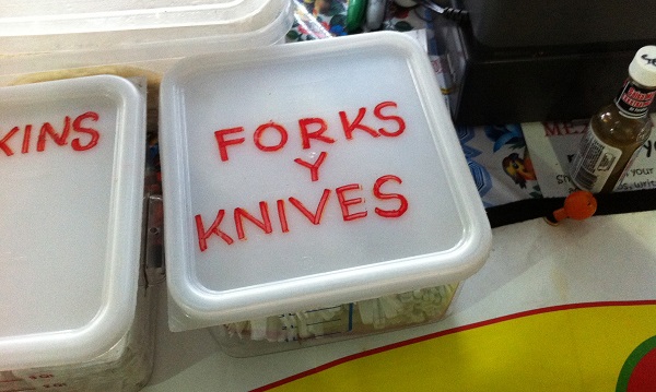Tupperware that says "Forks y knives" mixing Spanish and English
