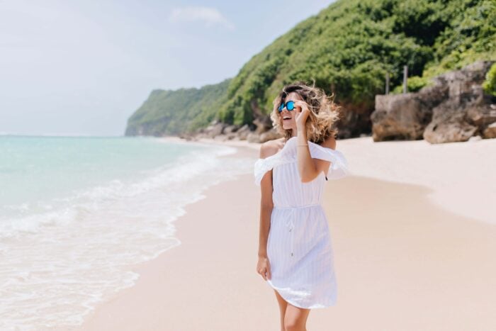 Woman walking along a Caribbean beach, one of the Dutch-speaking countries with a particular Dutch accent