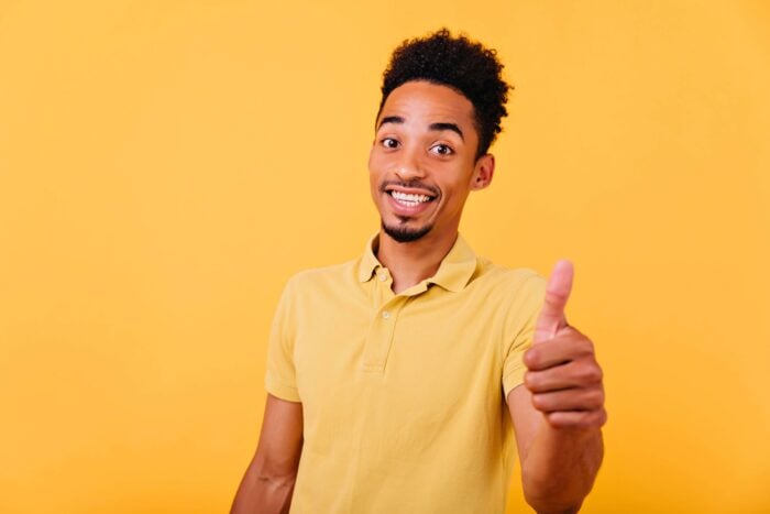 Brazilian man using one of these Portuguese slang terms while doing the thumbs up gesture.