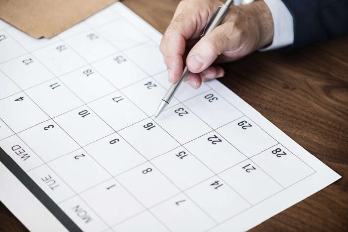 Man checking his calendar to write the date using Arabic numbers