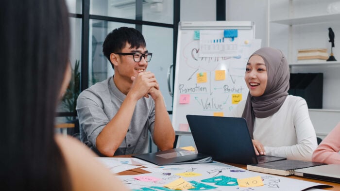 Multi-racial group discussing business using Arabic numbers