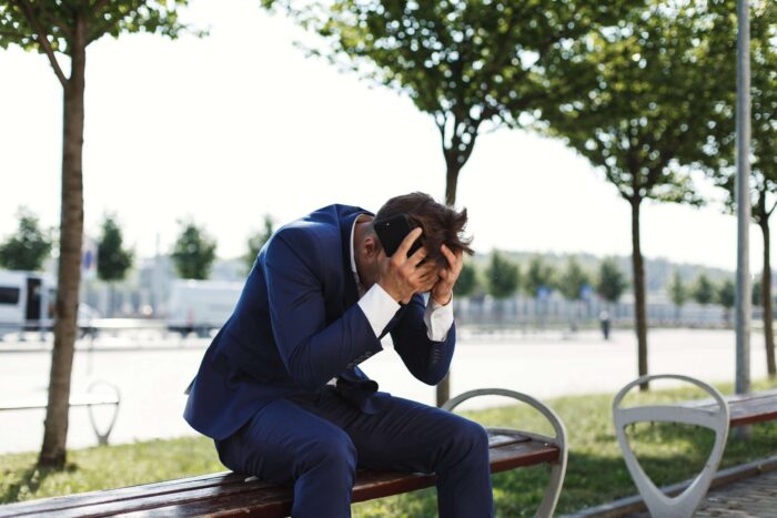 sad-businessman-sits-bank-outside-street-min-700x467.jpg