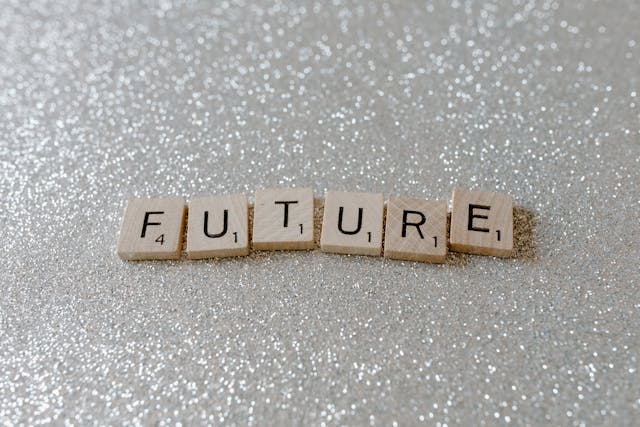 Wooden letter tiles spelling “future” on a glittery silver background