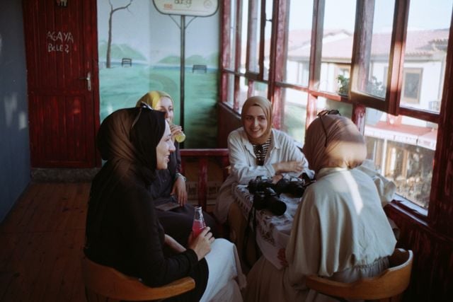 Women chatting together indoors, illustrating the kind of natural conversation useful for improving listening in Turkish.