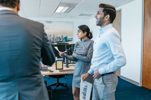 Colleagues presenting ideas in an office, reflecting the workplace communication goals of corporate language training.