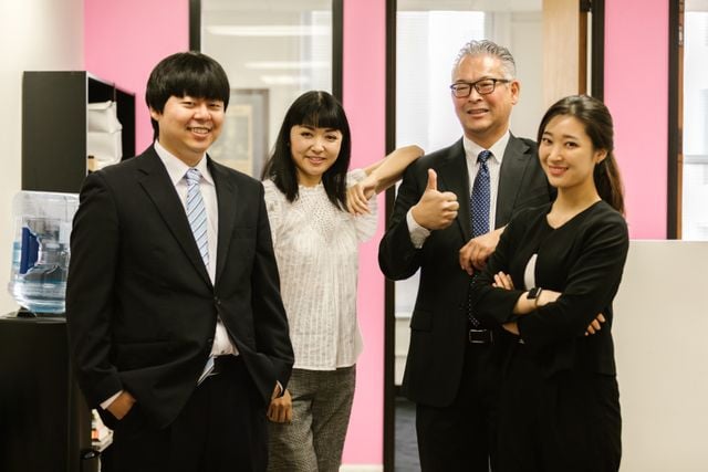 Four Korean professionals standing together in an office, illustrating workplace relationships and Korean terms of address.